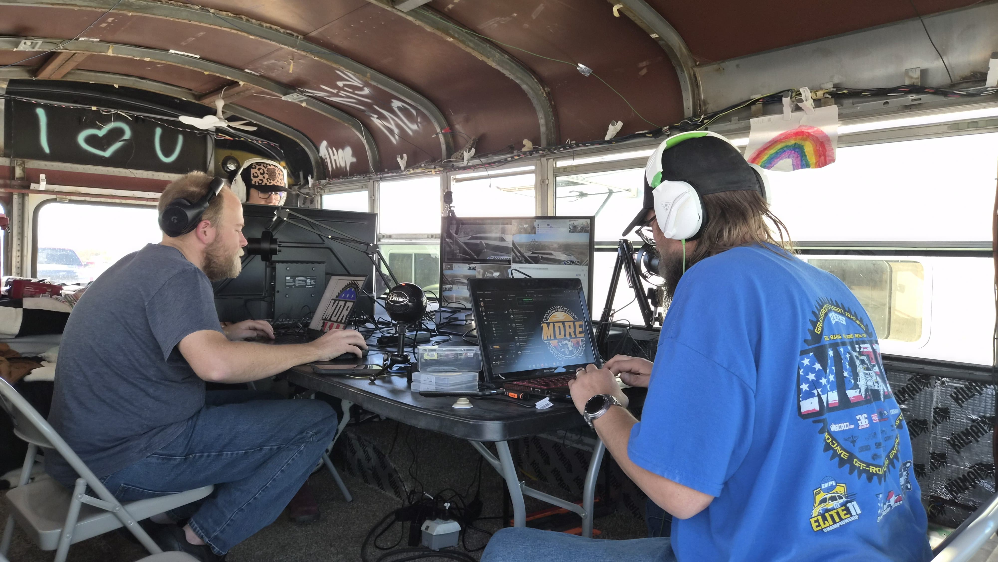 The stream production station with multiple monitors showing OBS, camera feeds, and chat